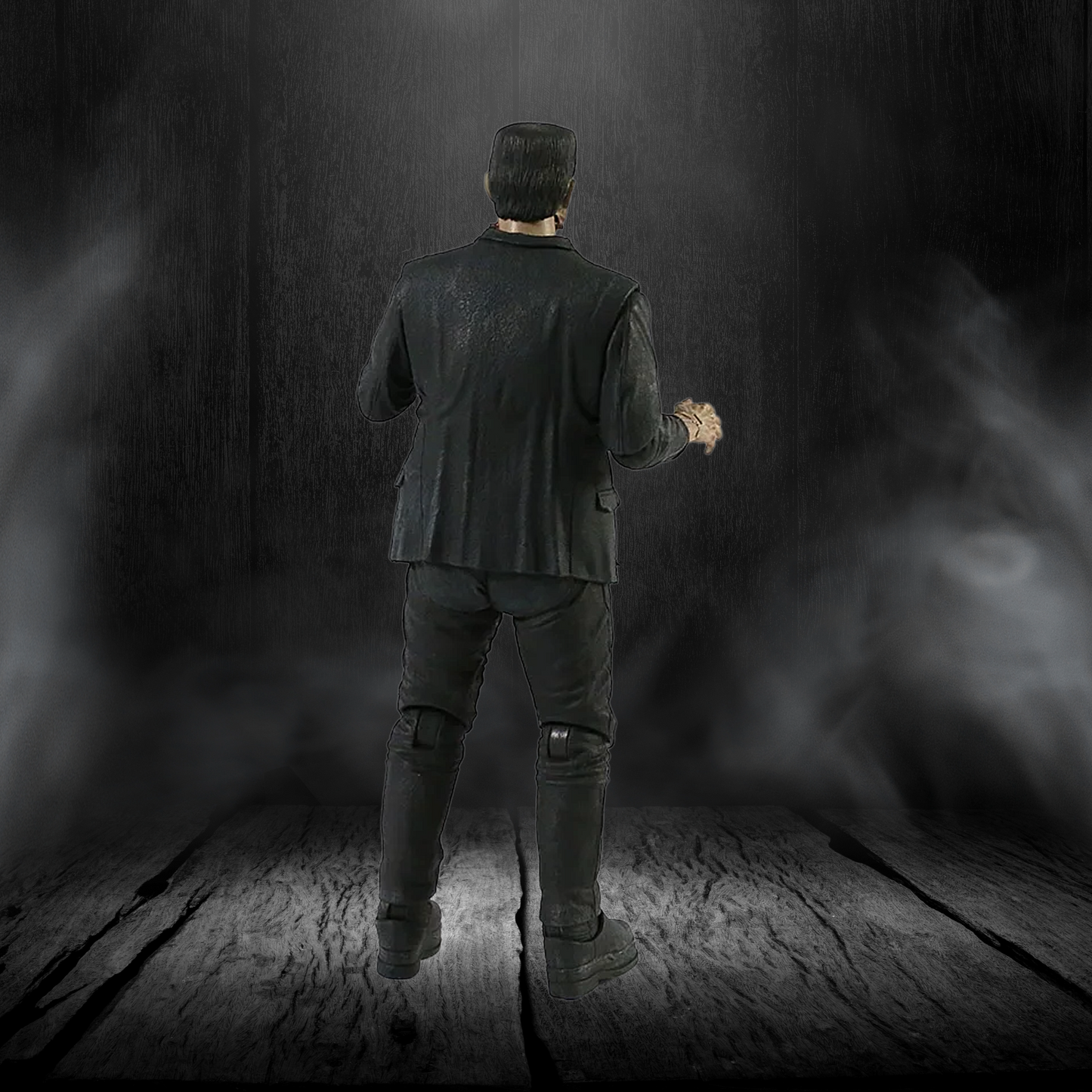 Person in dark clothing holding a flashlight in a dimly lit room