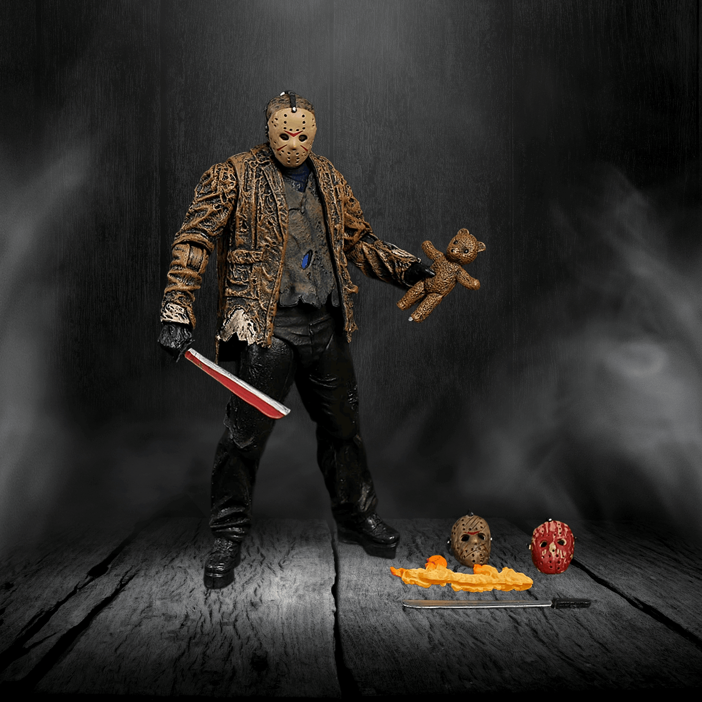 Action figure holding a teddy bear and knife on a dark background