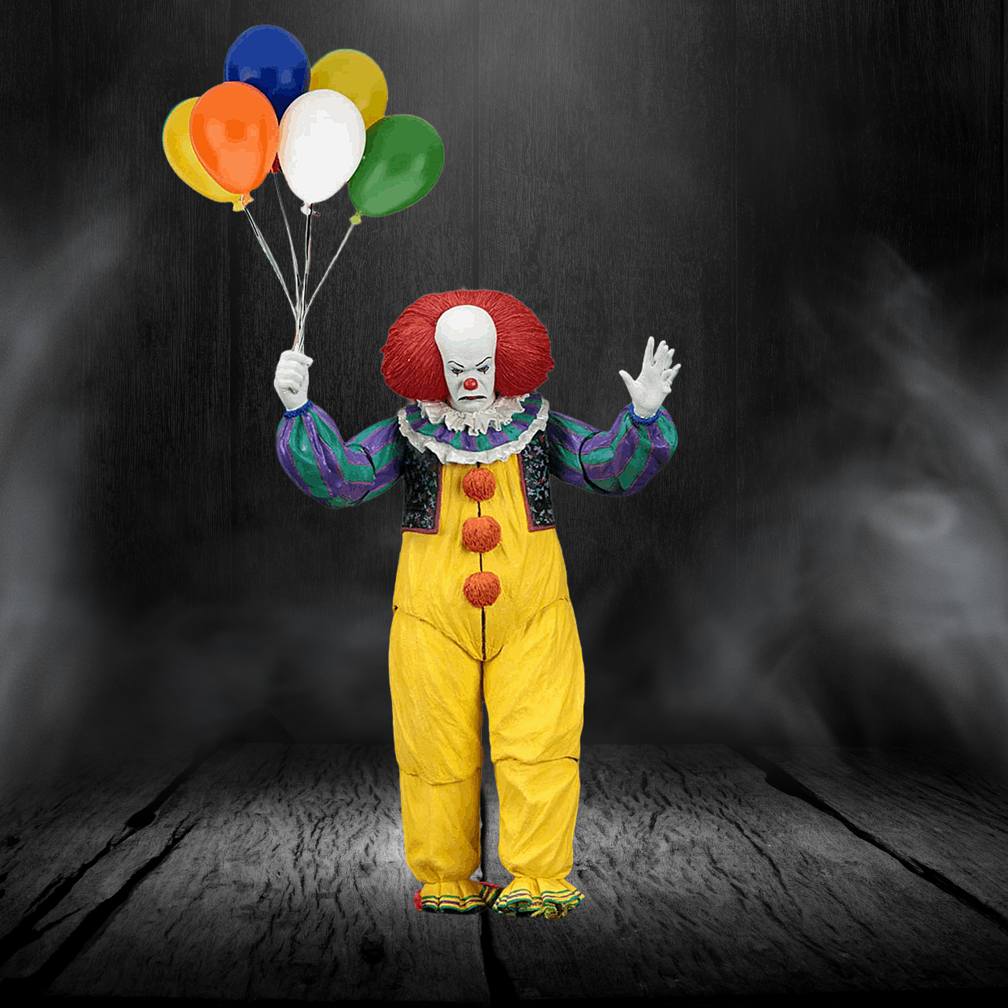 Clown in yellow suit with red hair and white face holding colorful balloons against a dark background