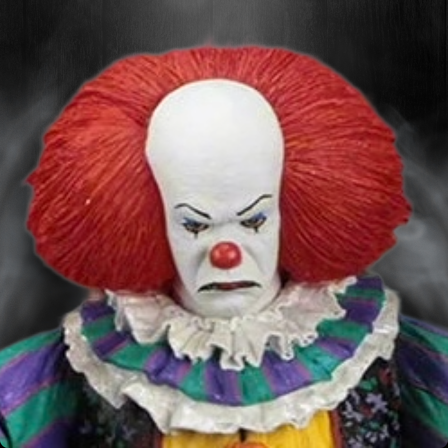 Clown figure with red hair and colorful outfit against a dark background