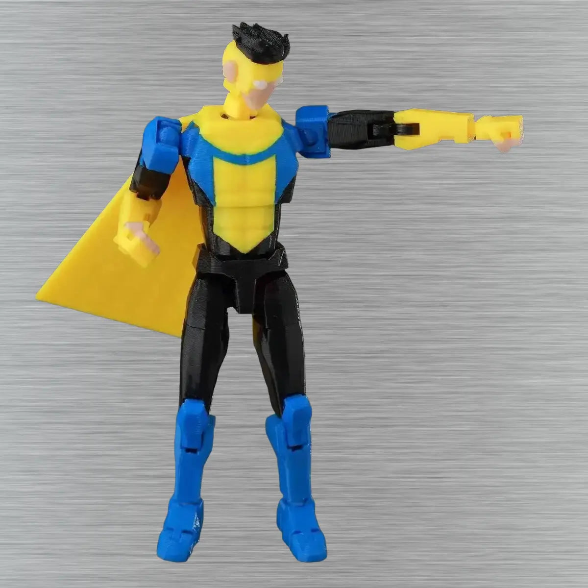 Superhero action figure with yellow cape and blue boots on a gray background