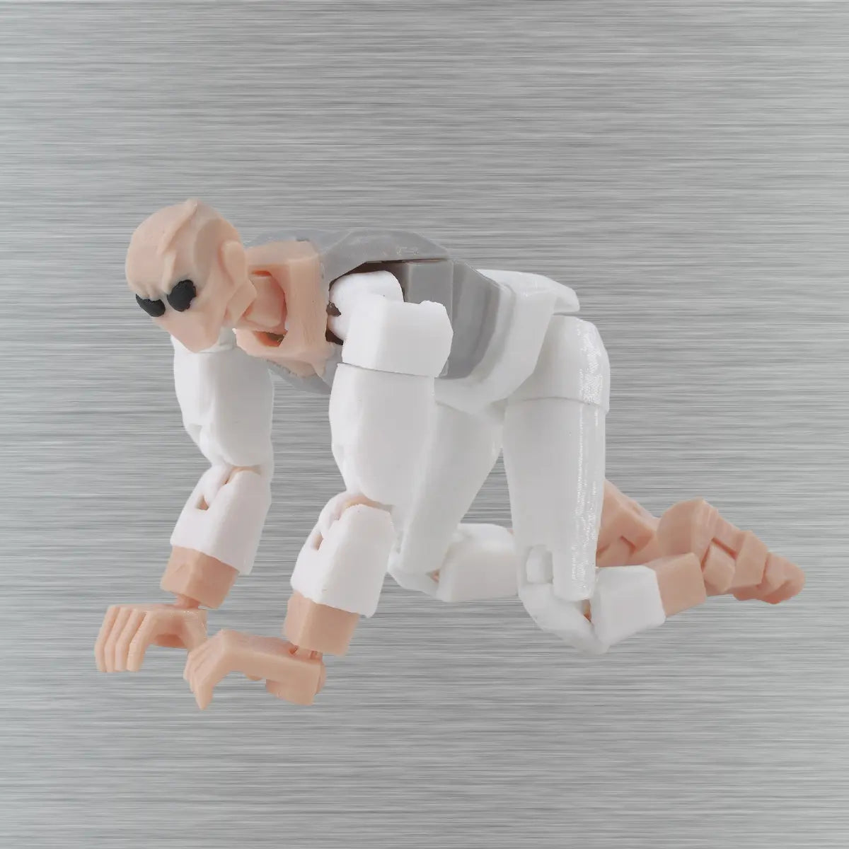Toy figure of a character with a gray head and pinkish-brown limbs on a textured gray background
