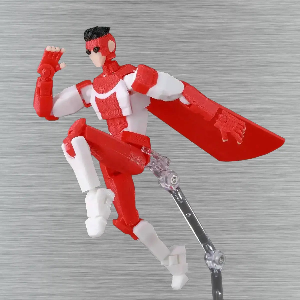 Red and white superhero action figure with a cape on a textured gray background