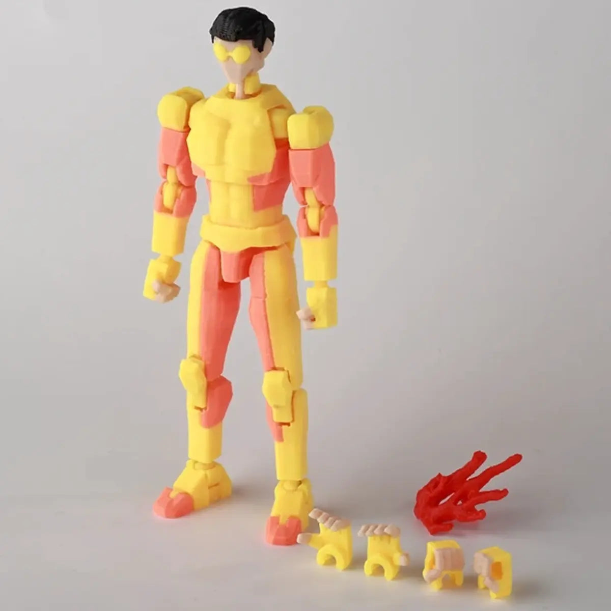 Yellow and pink action figure with interchangeable parts on a gray background