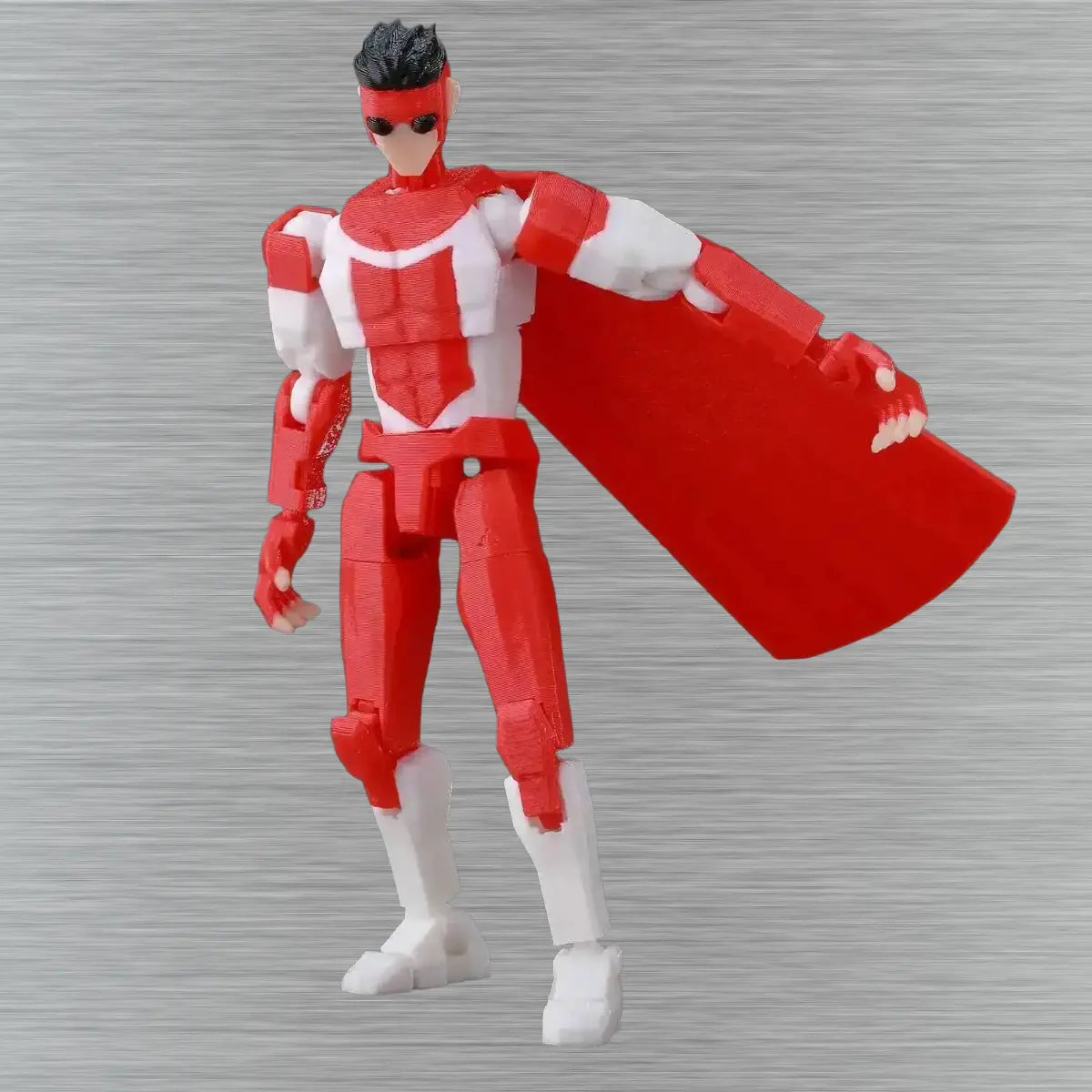 Red and white superhero action figure with cape on a gray background