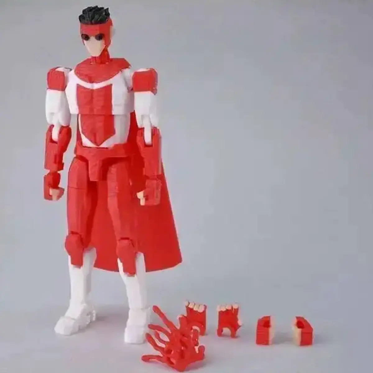 Red and white robot action figure with detachable parts on a gray background