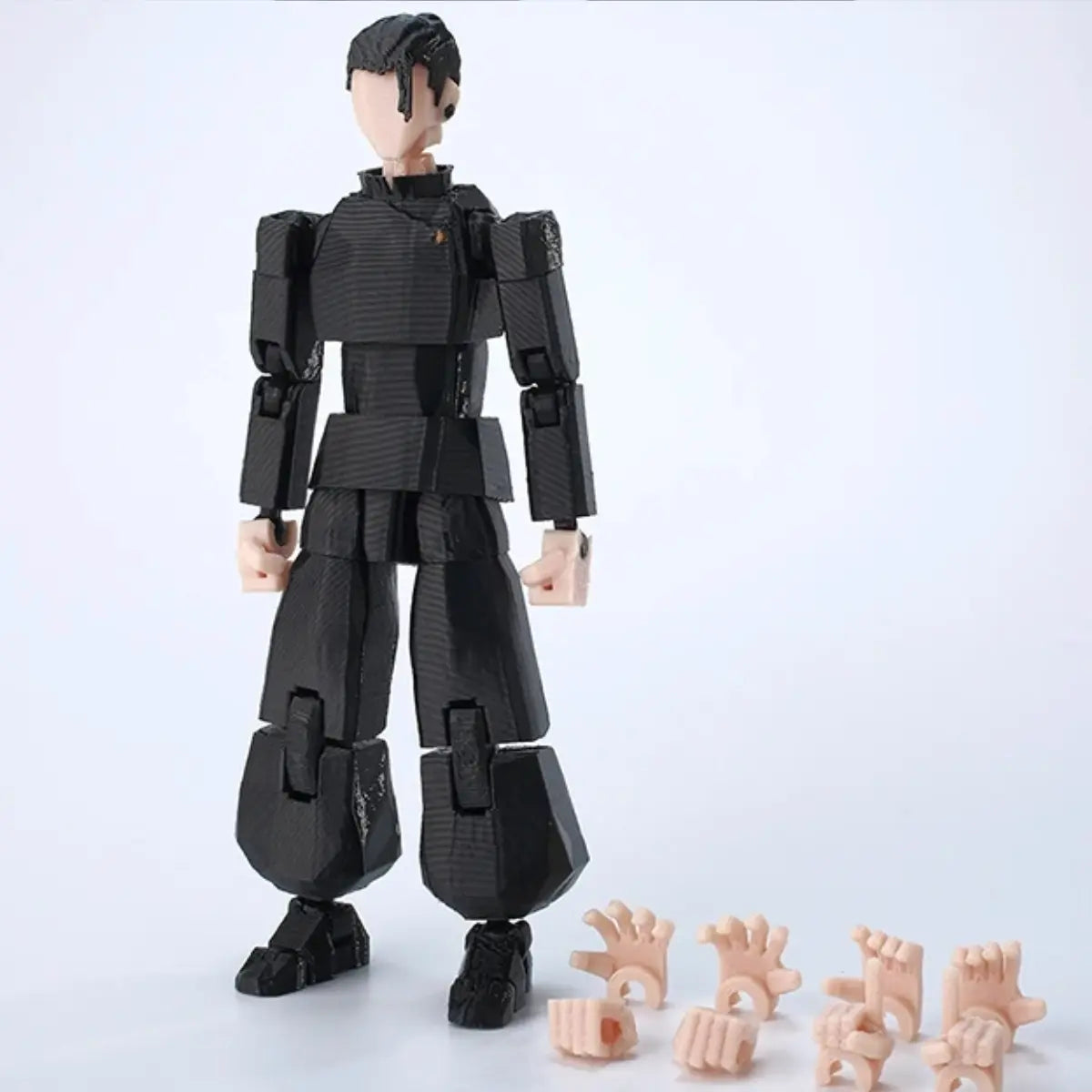 Black robot-like figure with interchangeable hands on a white background