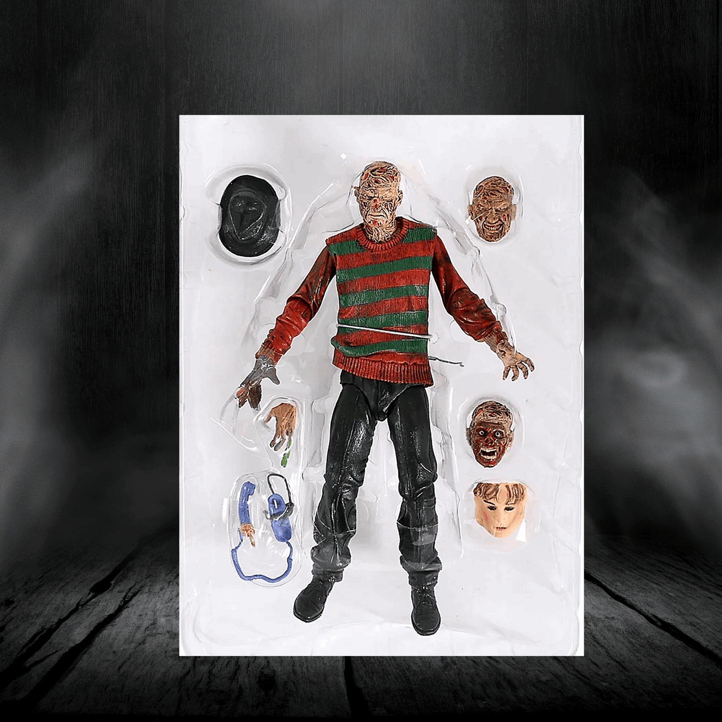 Action figure in a red sweater with multiple heads and props on a dark background