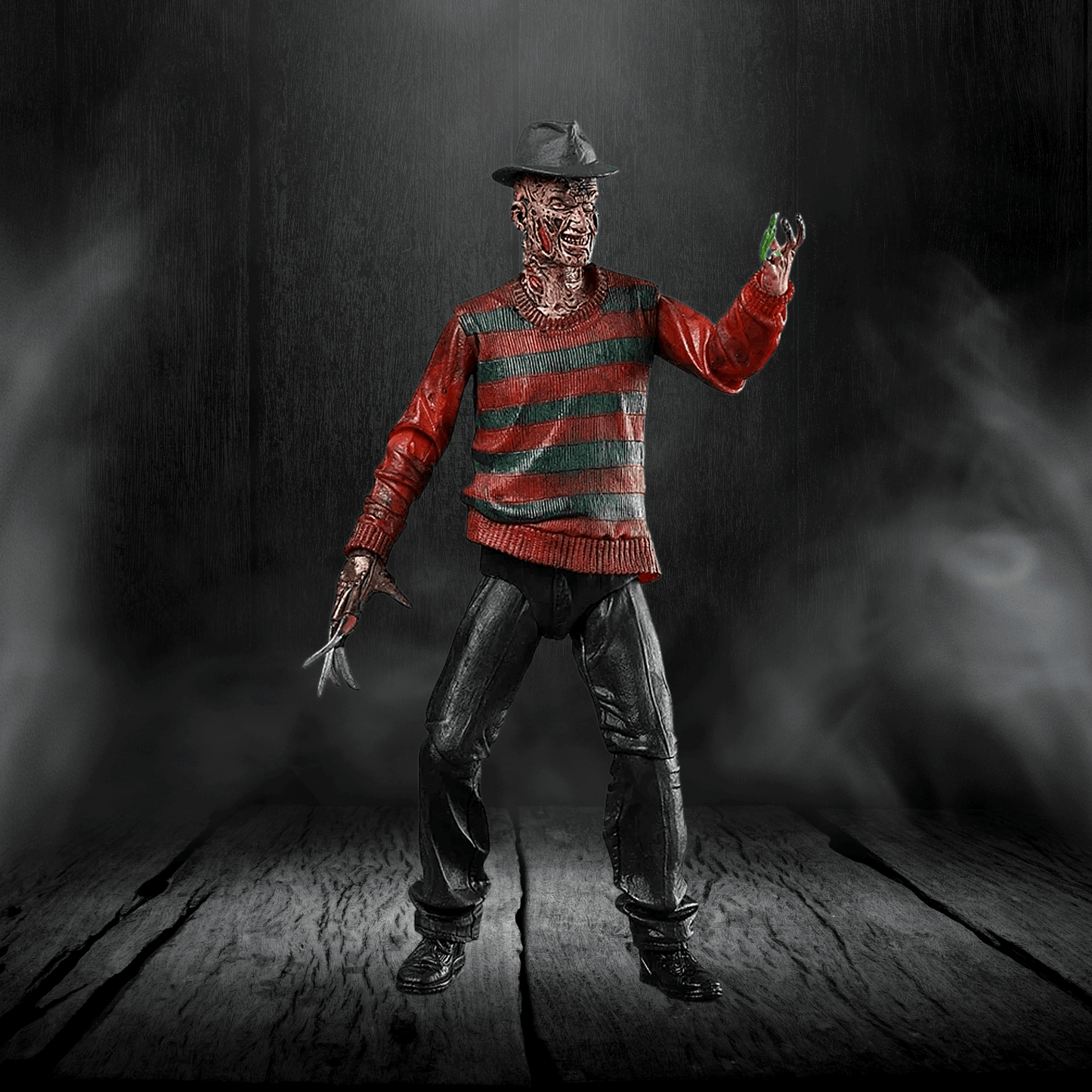 Action figure in a red and green striped sweater with a dark background