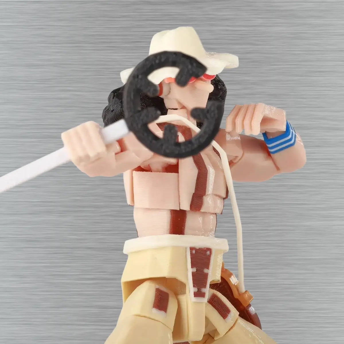 Action figure with a hat and weapon on a textured gray background