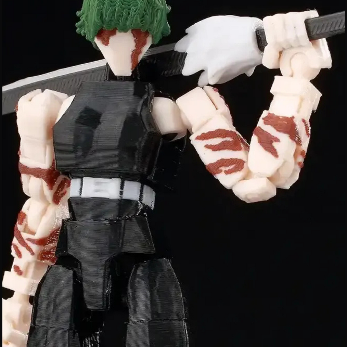 Action figure with a black outfit and green headband holding a sword on a black background