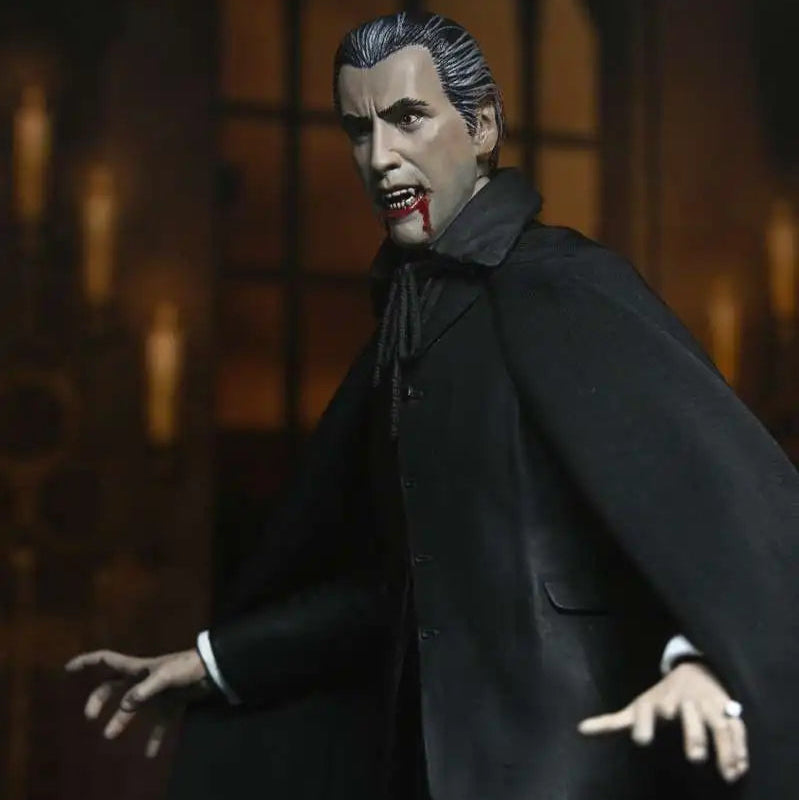 Action figure of a character in a dark suit with a cape against a blurred background