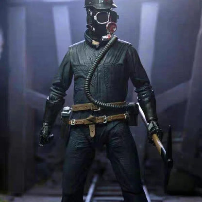 Action figure in a dark uniform with a gas mask and weapon, standing against a dark background.