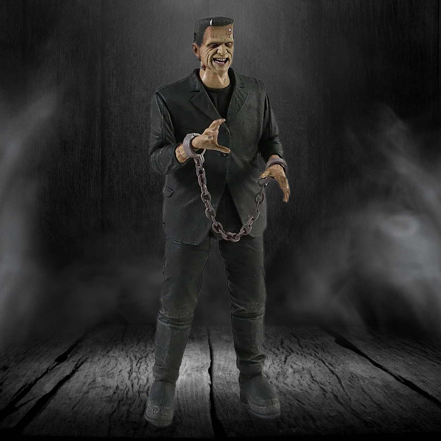 Action figure of a character in a dark suit holding chains against a dark background