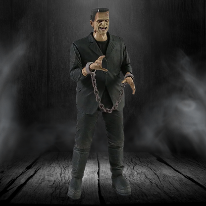 Action figure of a character in a dark suit holding chains against a dark background