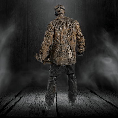 Bronze statue of a person wearing a textured jacket on a dark background