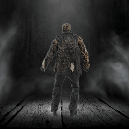 Mannequin in camouflage clothing standing on a wooden floor with a dark, smoky background