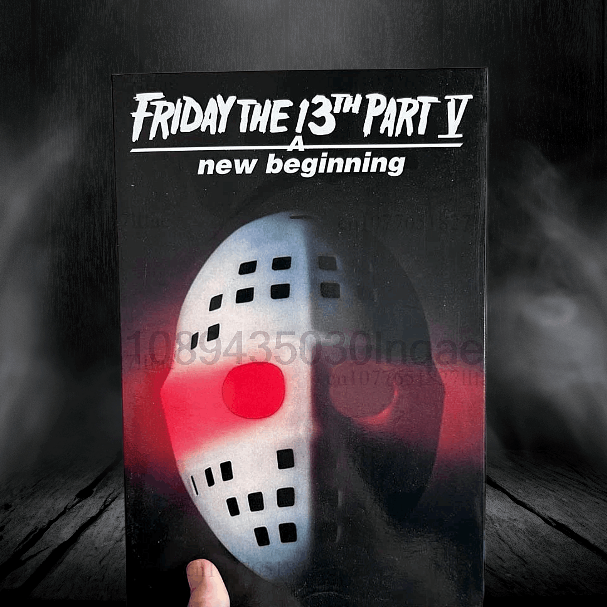 Movie poster for 'Friday the 13th Part V: New Beginning' with a mask design.