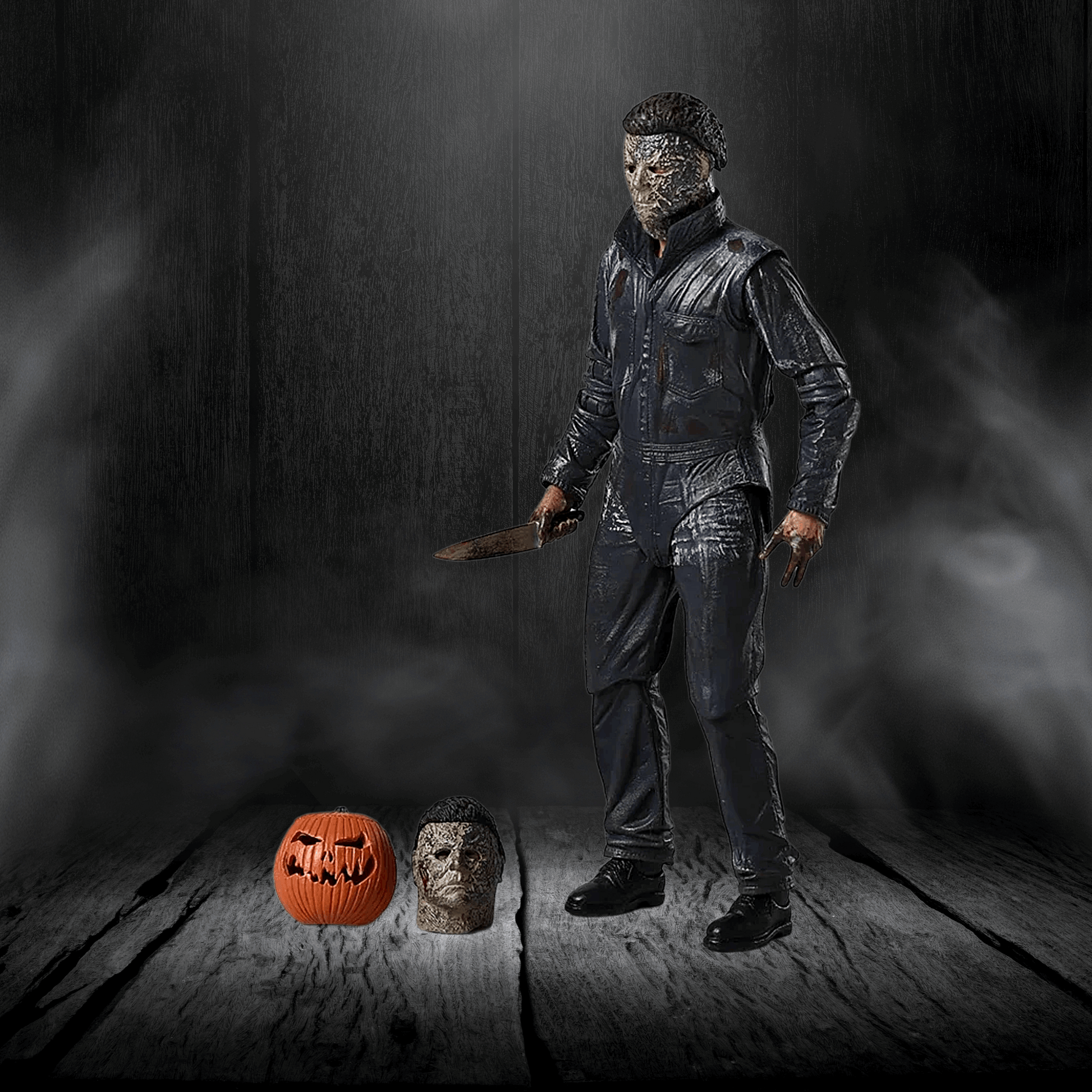 Person in a dark costume holding a knife, with a pumpkin and another figure on a wooden floor.