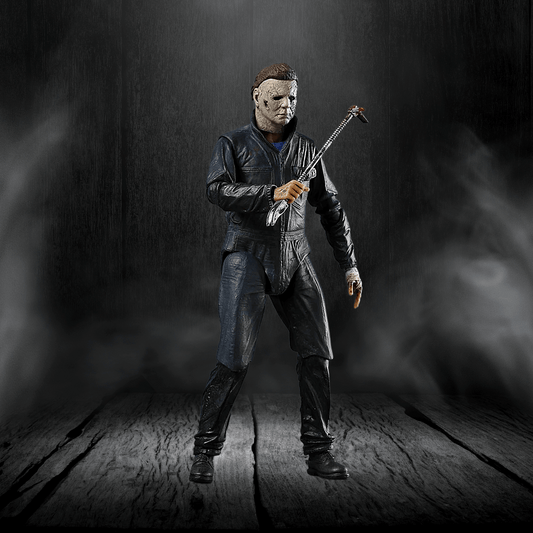 Action figure in a dark setting holding a weapon