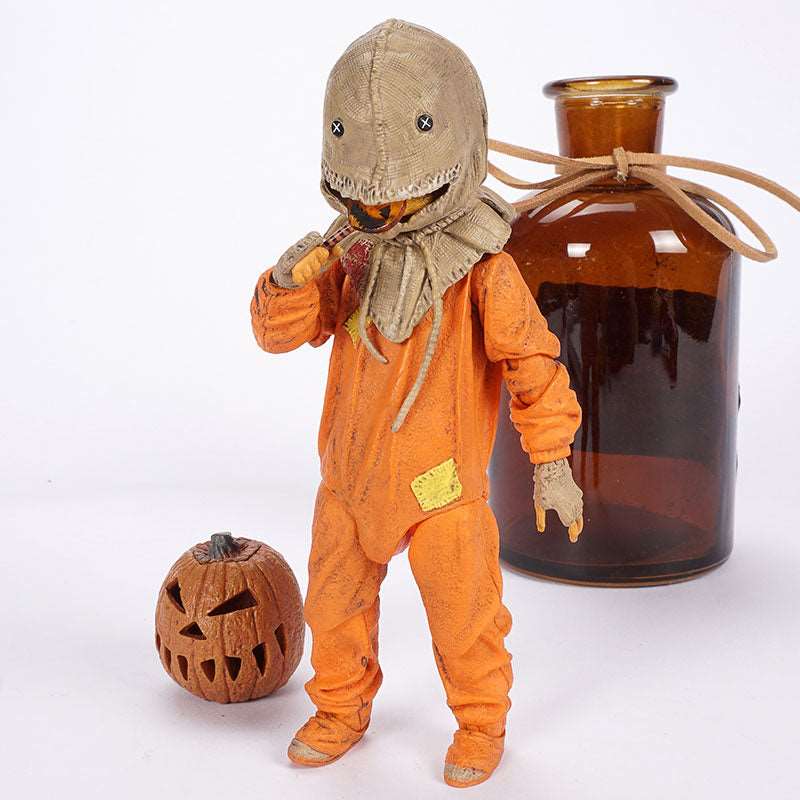 Scarecrow-like figure in an orange outfit with a hat, next to a carved pumpkin and amber glass bottle on a white background