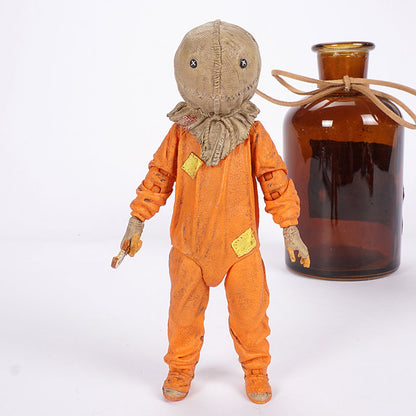 Vintage-style doll in an orange suit next to a brown bottle on a white background