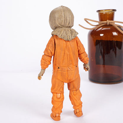 Action figure in an orange suit with a brown bottle on a white background