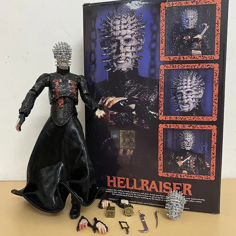 Action figure of Pinhead from Hellraiser with packaging and accessories on a beige surface.