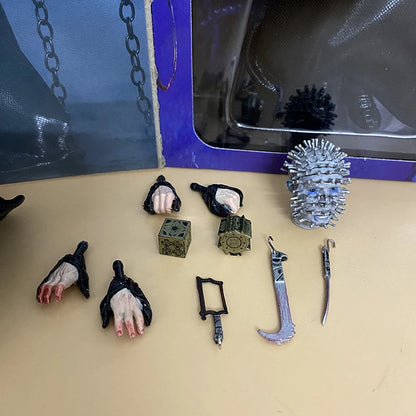 Collection of horror-themed props including hands, tools, and a spiked ball on a beige surface.