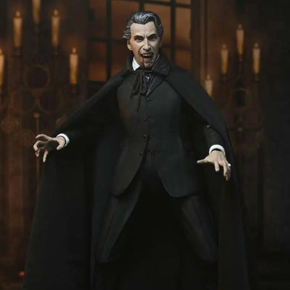 Action figure of a character in a dark suit with a cape against a candlelit background