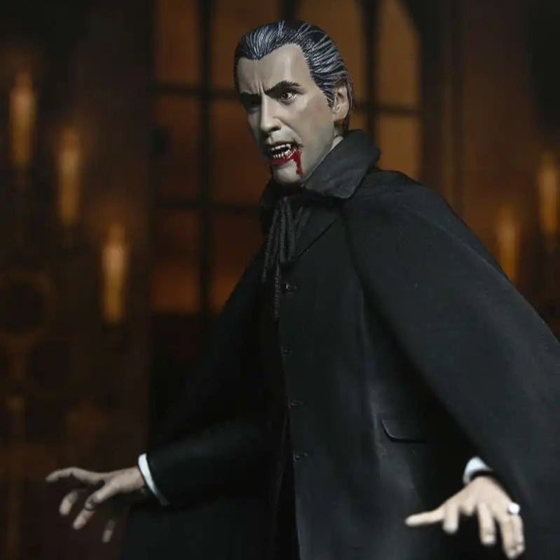 Action figure of a character in a dark suit with a cape against a blurred background