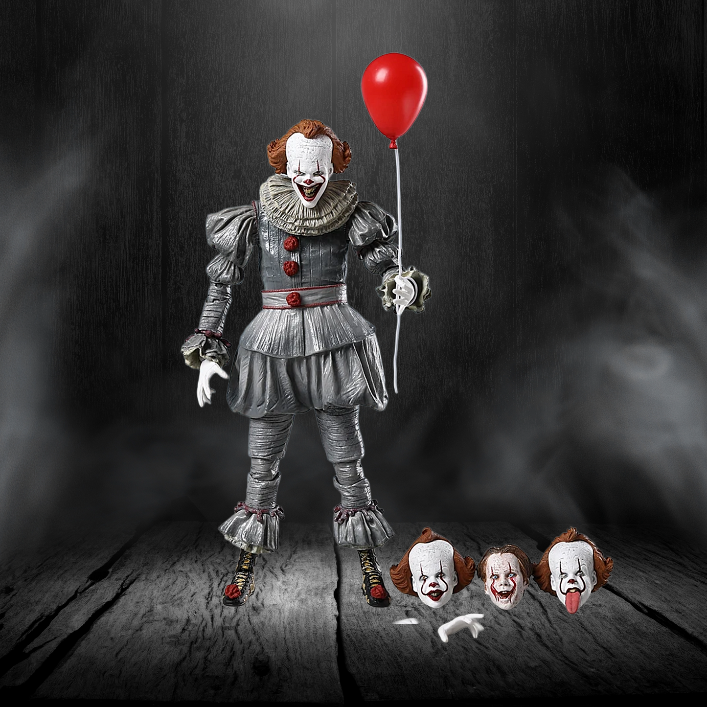 Action figure of a clown holding a red balloon with smaller versions of itself on a dark background