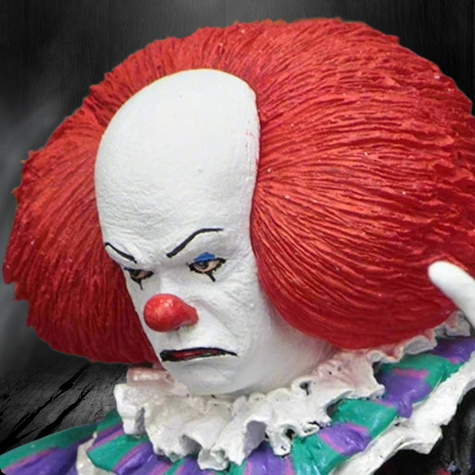 Close-up of a clown figure with red hair and white face against a dark background