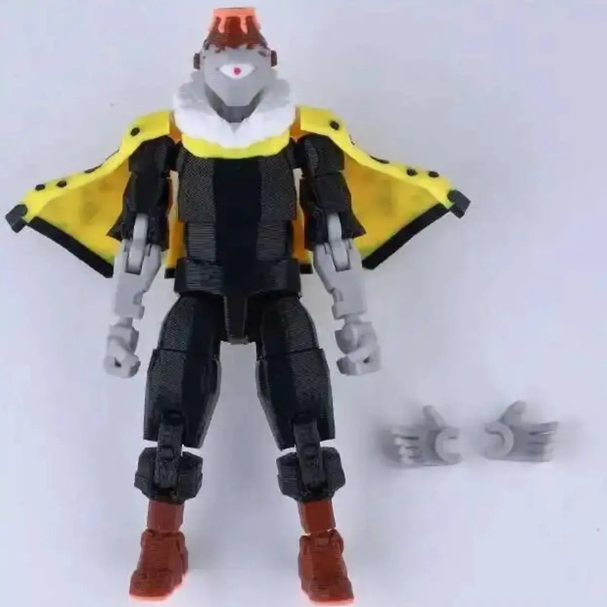 Toy figure with a yellow cape and red shoes on a white background