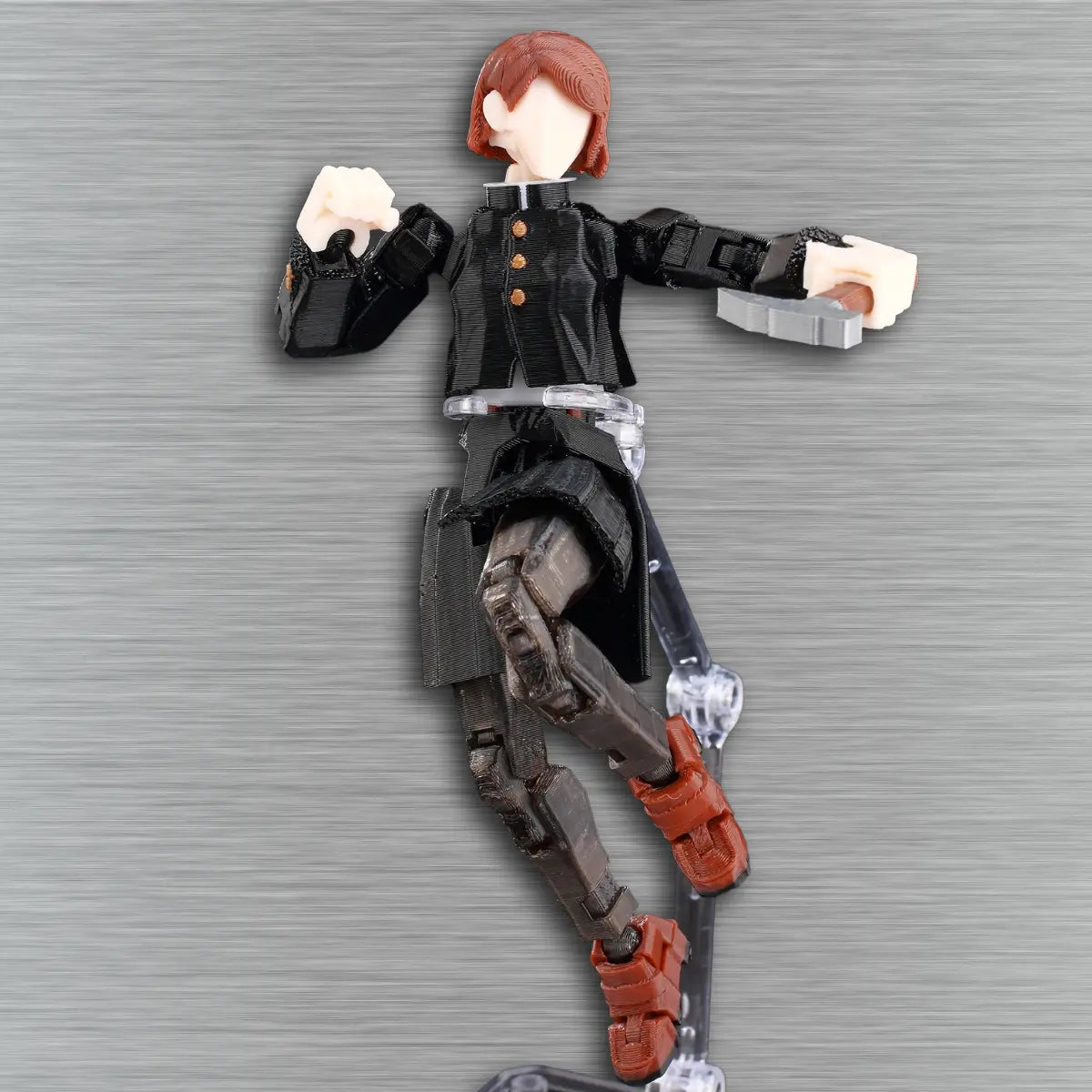 Action figure of a character in a black outfit with red hair against a gray background