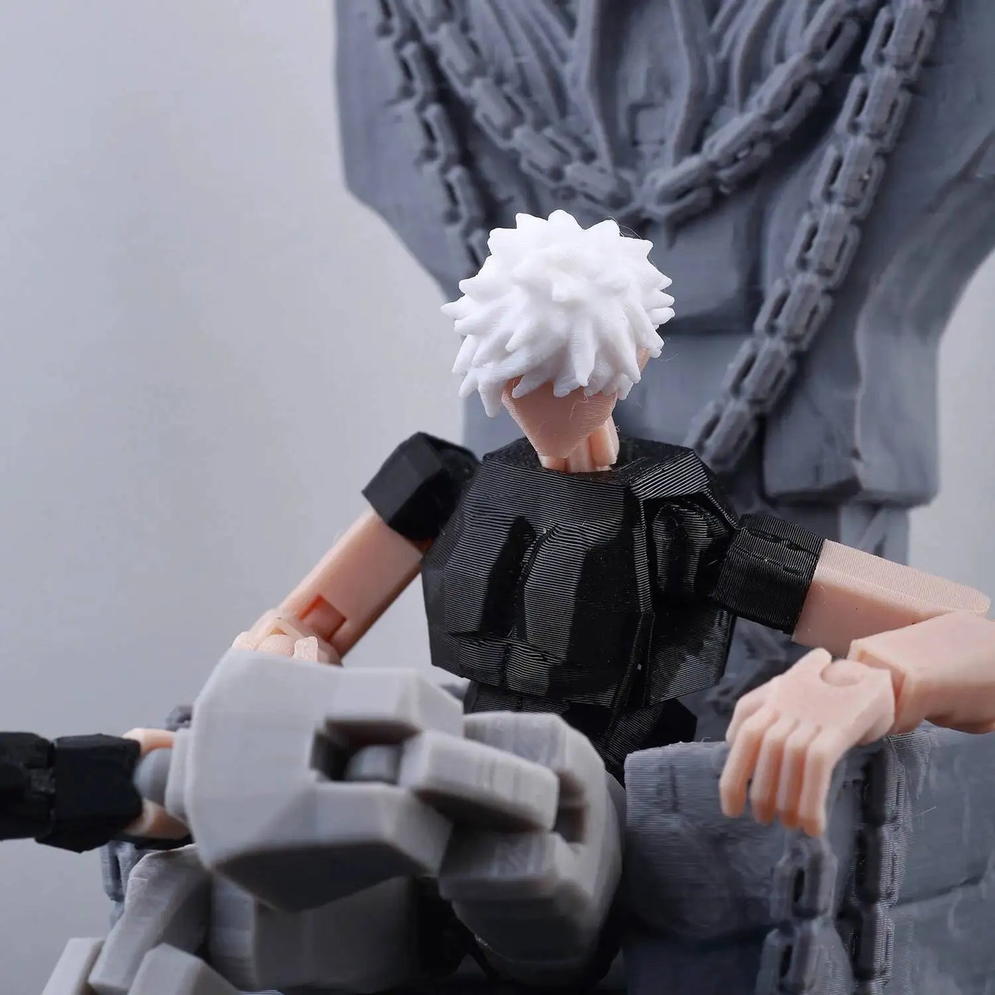 Action figure with white hair and black outfit against a gray background