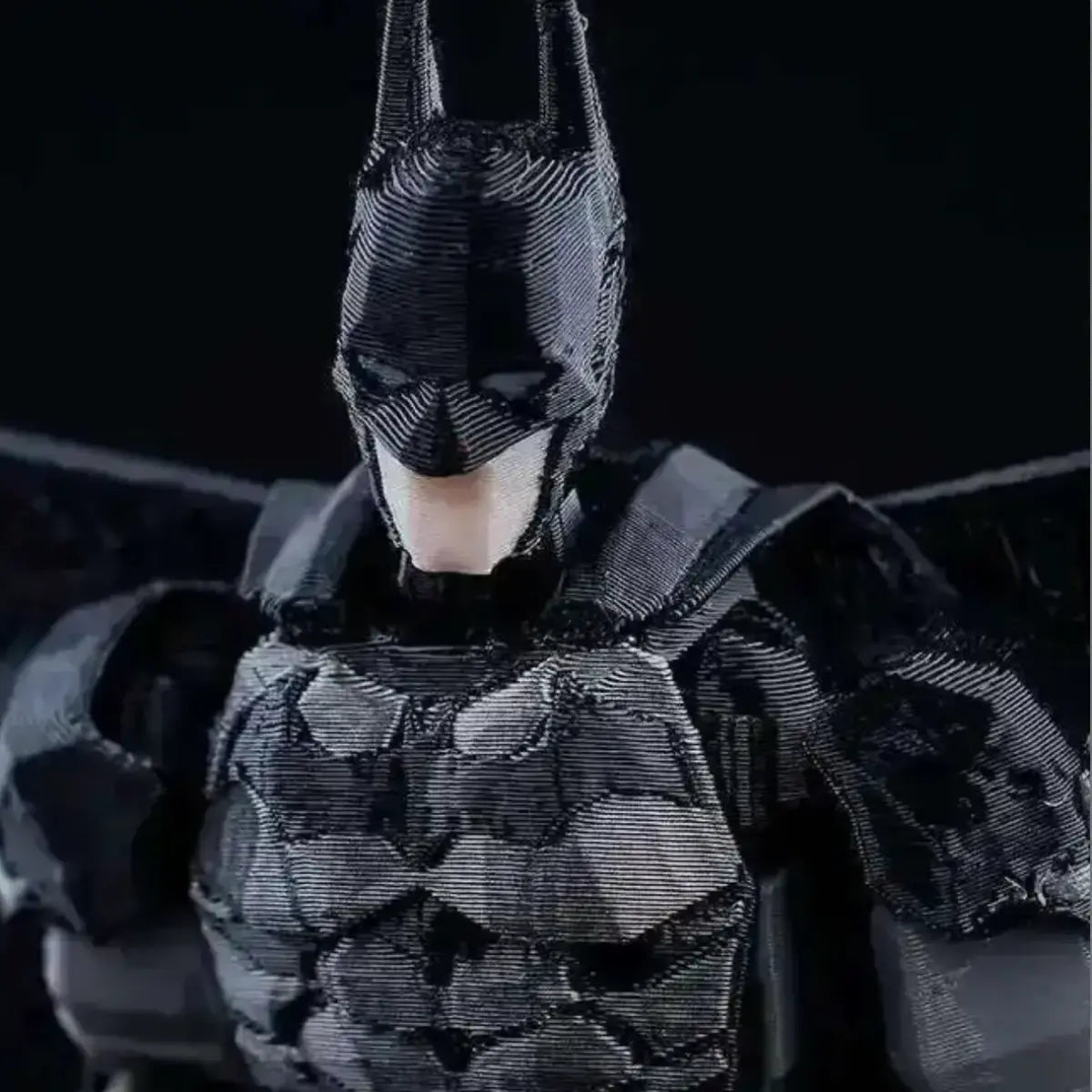 Person wearing a detailed Batman costume against a dark background