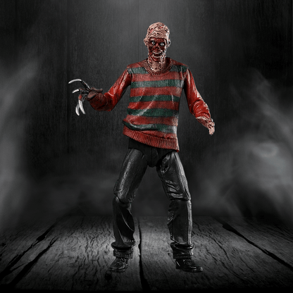 Action figure in a red and green striped sweater with a dark background