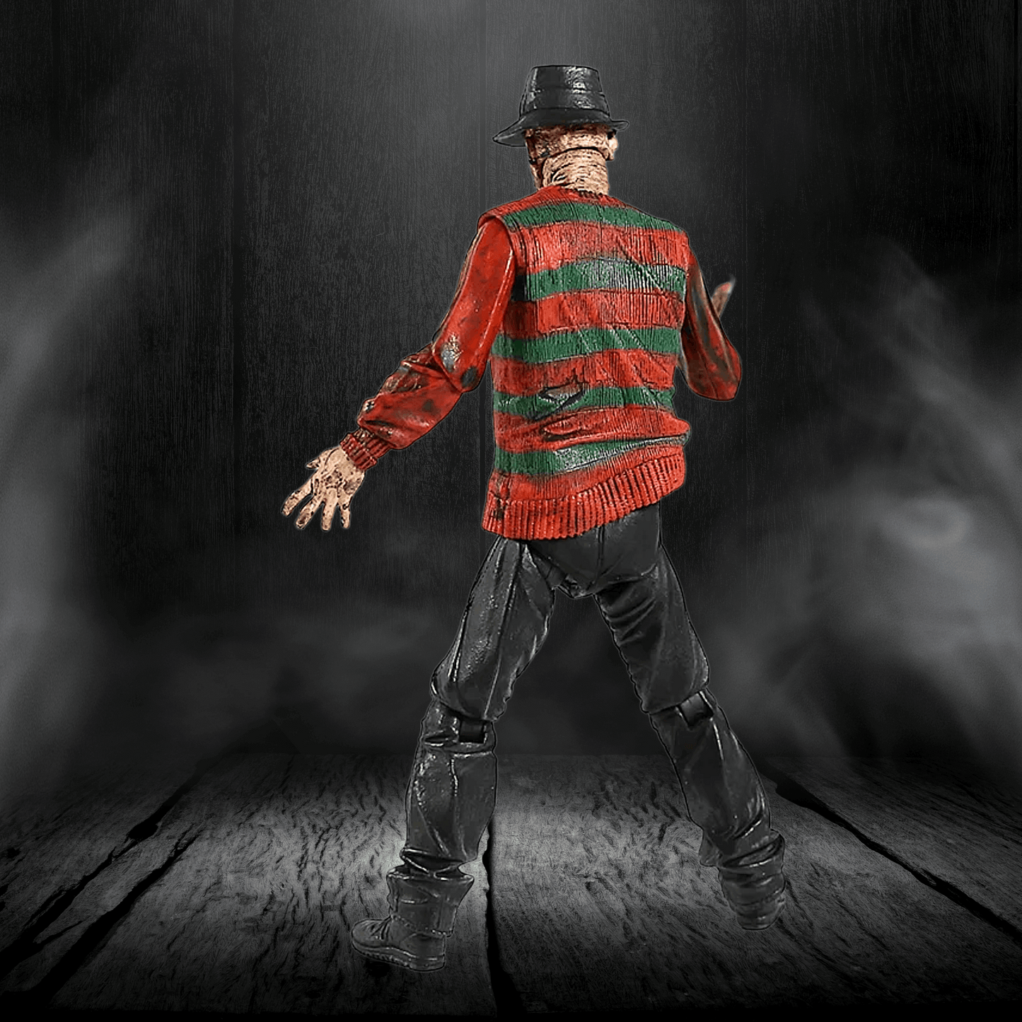 Action figure in a red and green sweater with a dark background