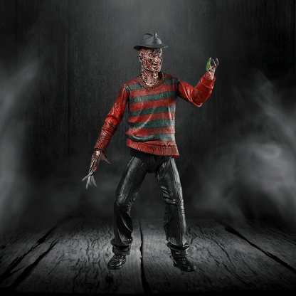 Action figure in a red and green striped sweater with a dark background