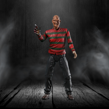 Action figure in a red and green striped sweater with a dark background