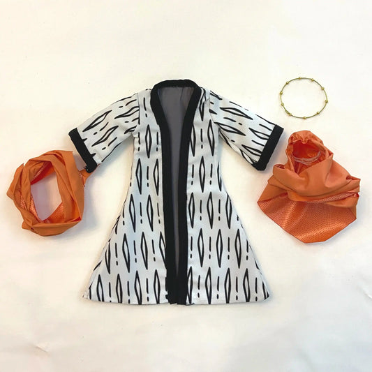 White dress with black pattern, orange headscarf, and bracelet on a light background