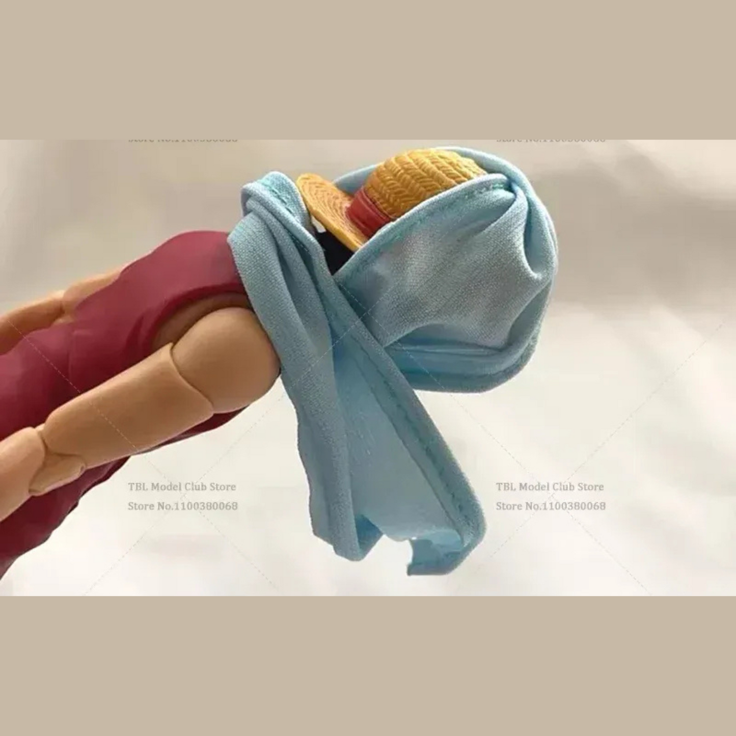 Toy figure holding a blue towel with food items on a plain background