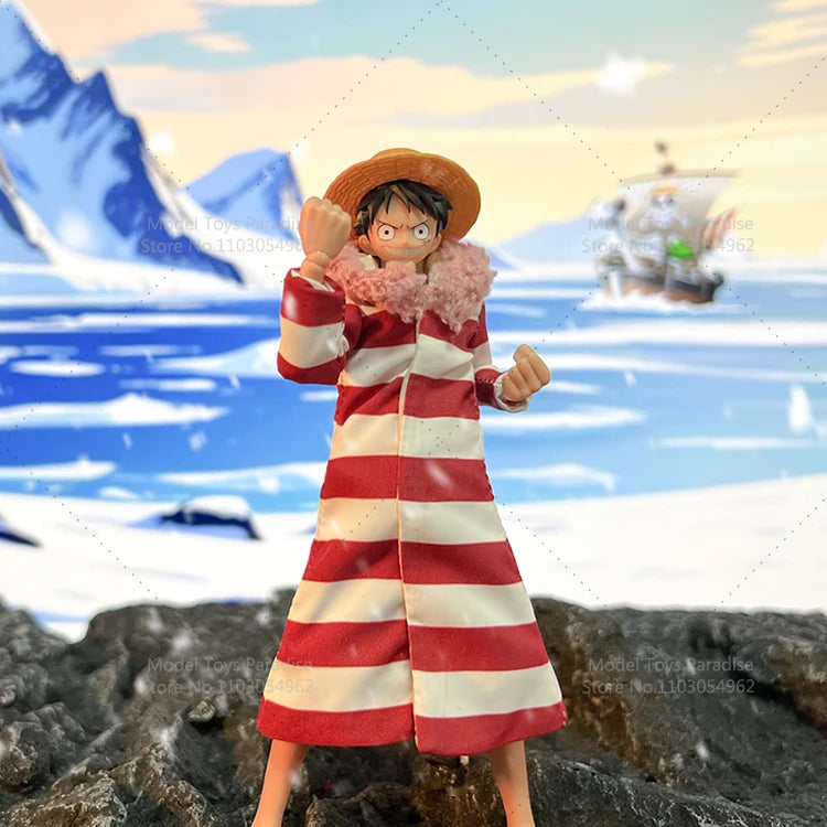 Action figure in a red and white striped outfit with a straw hat on a beach background