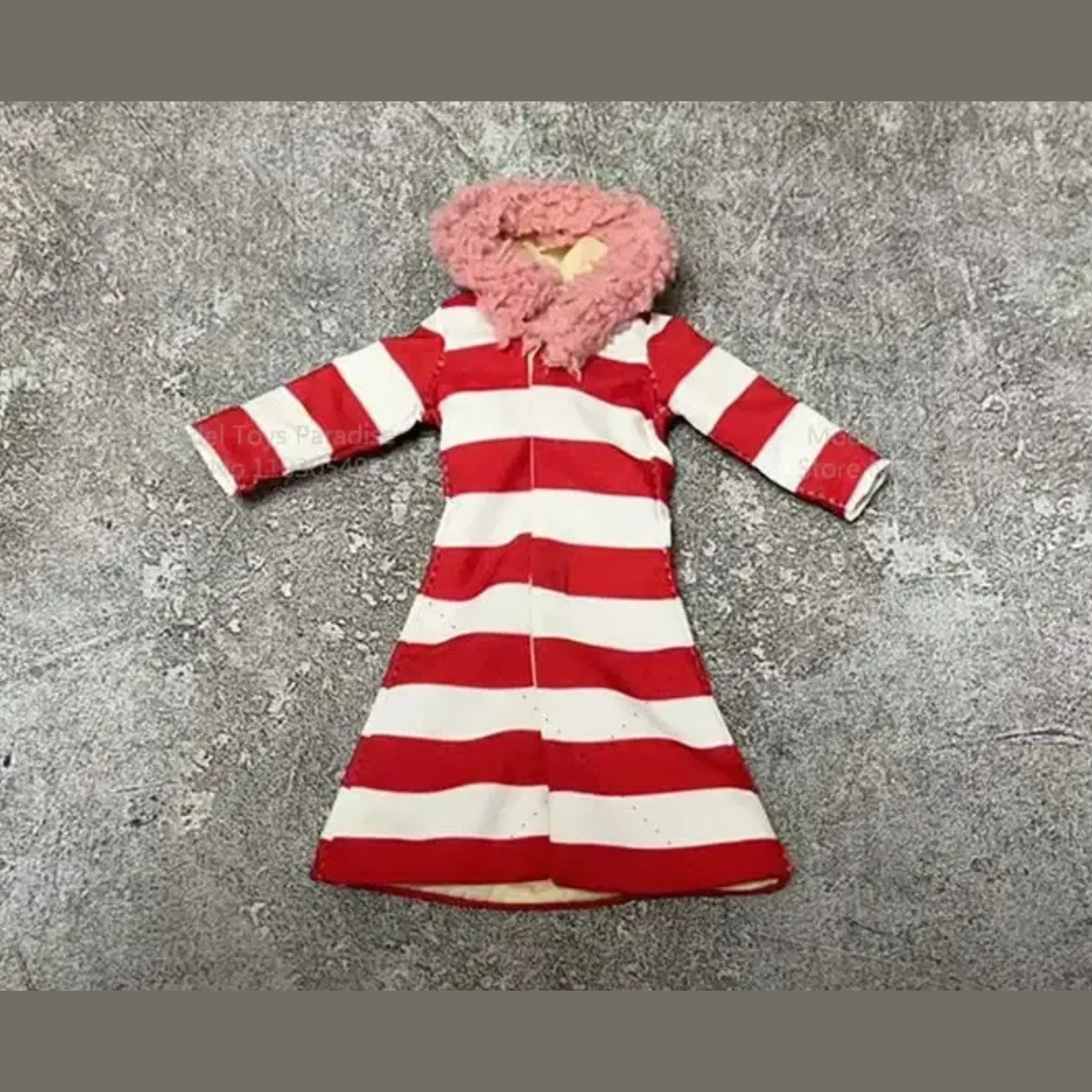 Red and white striped dress with pink hood on a gray concrete surface