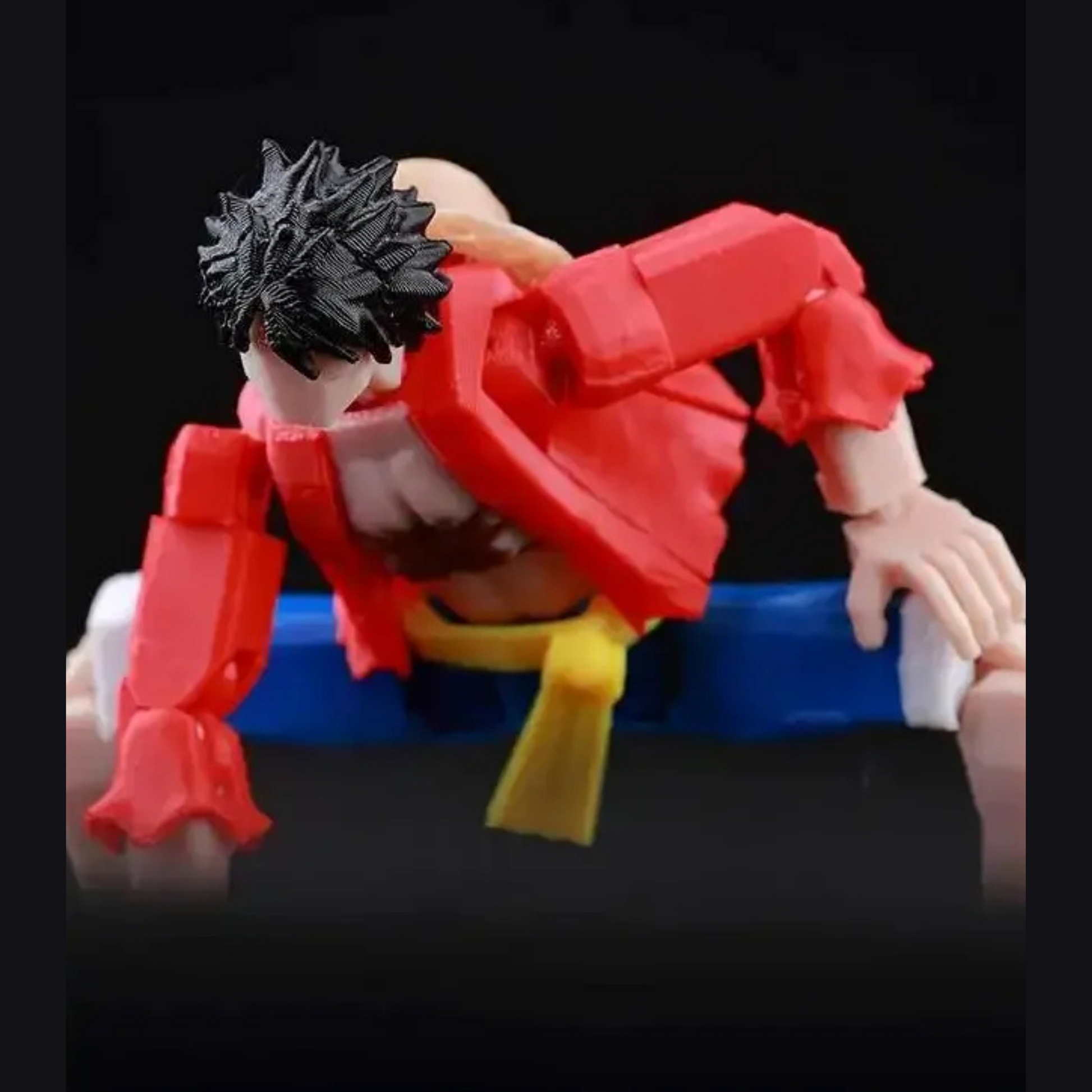 Action figure with red outfit and black hair on a black background