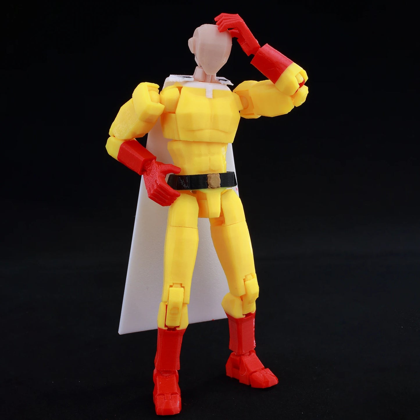Action figure with yellow and red costume on a black background