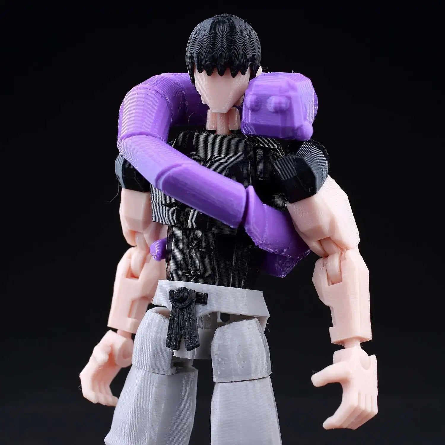 Action figure with purple arm and black hair on a black background