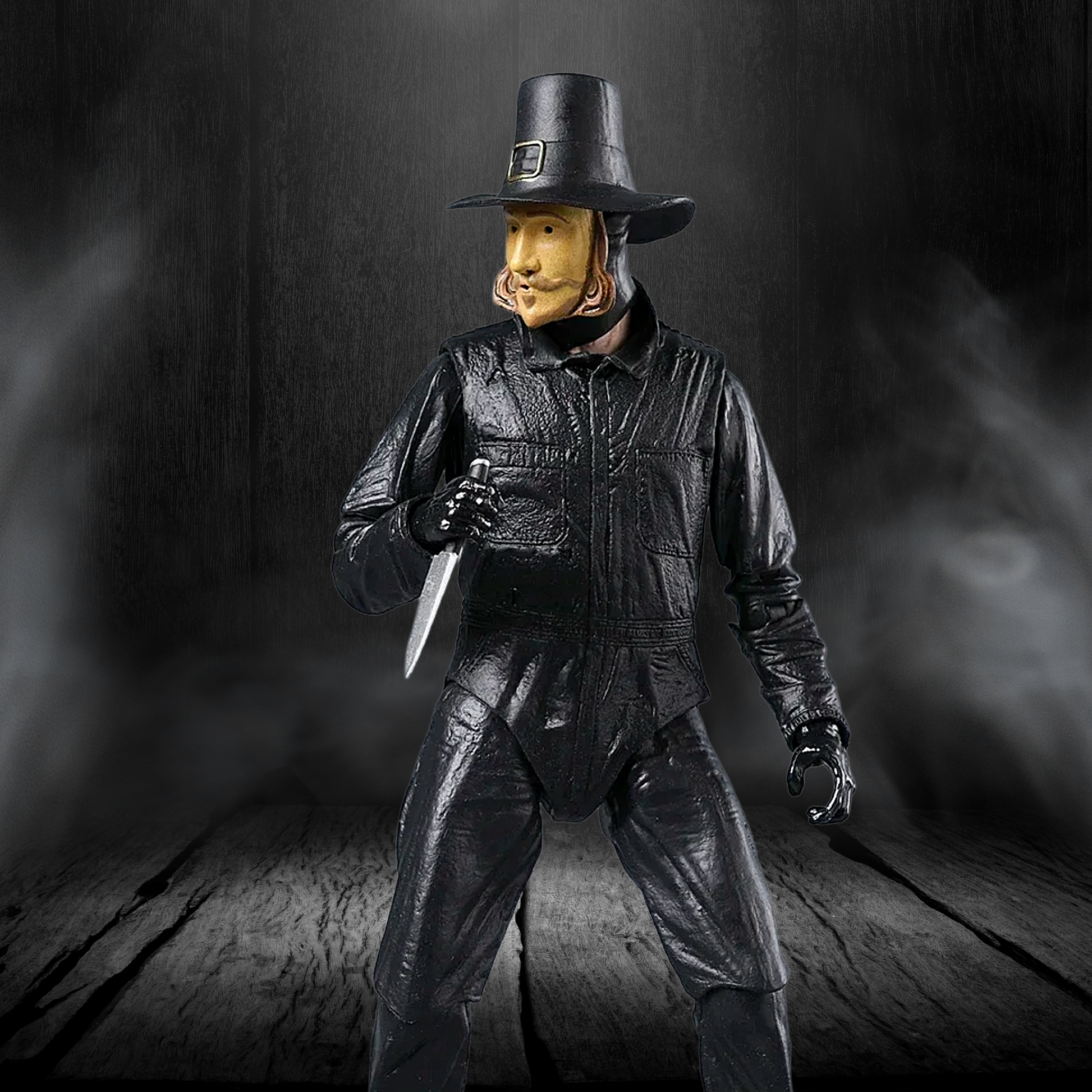 Figure in black leather outfit with hat and knife on a dark background