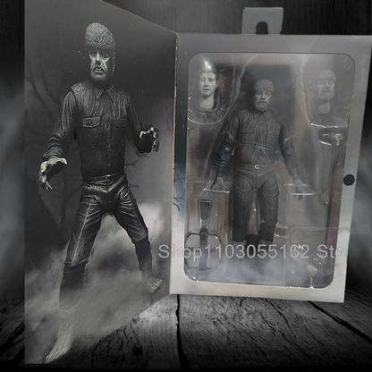 Action figure of a character in a dark outfit with a gun, next to its packaging on a wooden surface.
